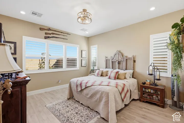 Wood-finish flooring, plantation shutters, recessed lighting, and a drum-style semi-flush mount ceiling fixture