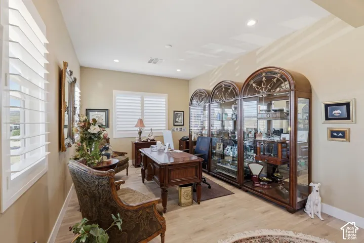 Built-in triple-arch cabinetry, light-toned wood-finish flooring, recessed lighting, and interior plantation shutters