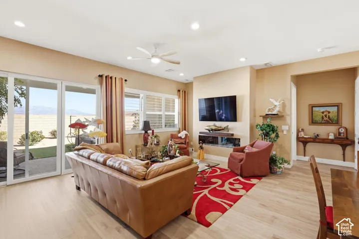 Living area featuring recessed lighting, wood-finish flooring, a contemporary horizontal fireplace, and expansive sliding glass doors