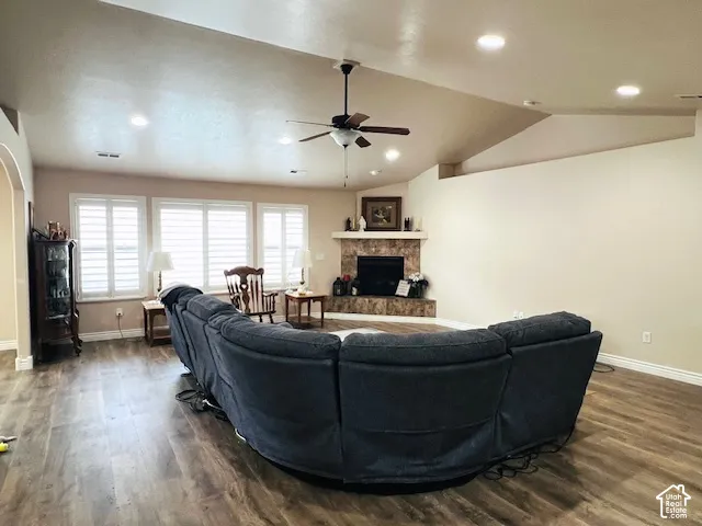 Vaulted ceilings, wood-finish flooring, corner fireplace with tile surround, recessed lighting, and plantation shutters