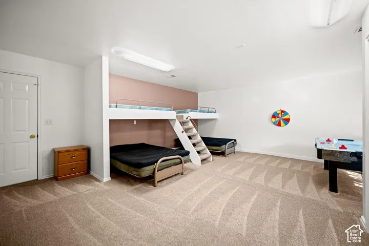 Spacious room featuring neutral carpeting, a built-in bunk bed structure with an integrated staircase, and surface-mounted ceiling lighting