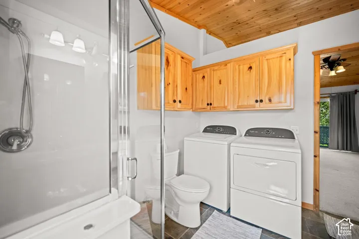 Bathroom featuring a glass-enclosed shower, natural wood cabinetry, wood-paneled ceiling, and stone-finish flooring