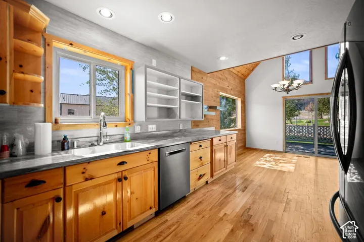 Kitchen featuring natural wood cabinetry, stone-surface countertops, wood-finish flooring, recessed lighting, and vaulted ceilings with expansive windows