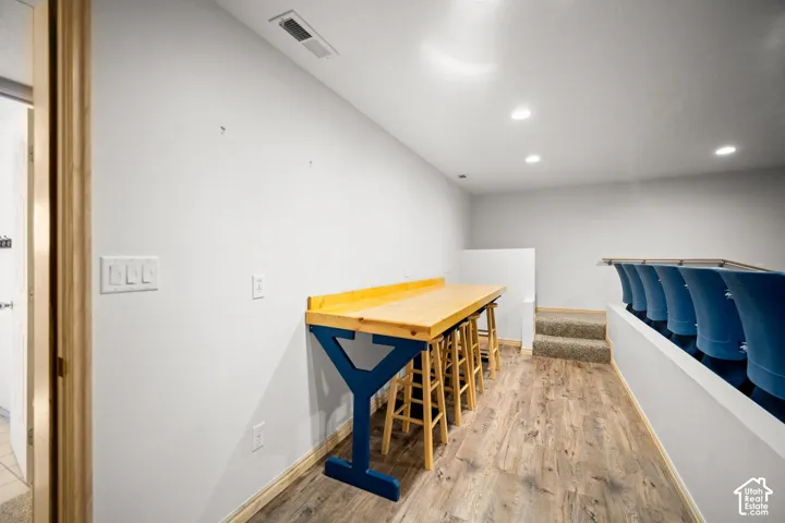 Built-in wood-topped counter with custom support, recessed lighting, and wood-finish flooring