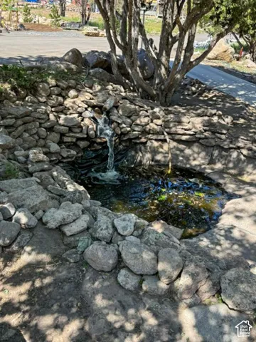 Natural stone water feature with tiered rock retaining wall and integrated basin