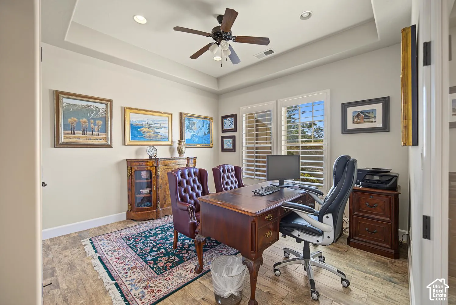 Tray ceiling featuring recessed lighting, ceiling fan with light kit, and plantation shutters