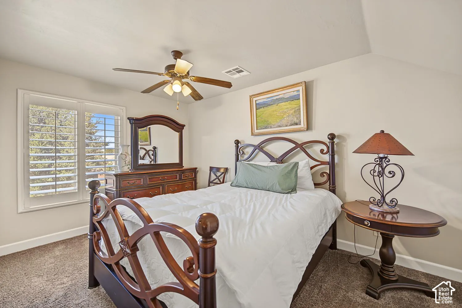 Neutral wall coloring, plantation-style window shutters, and a ceiling-mounted light fixture with integrated fan blades