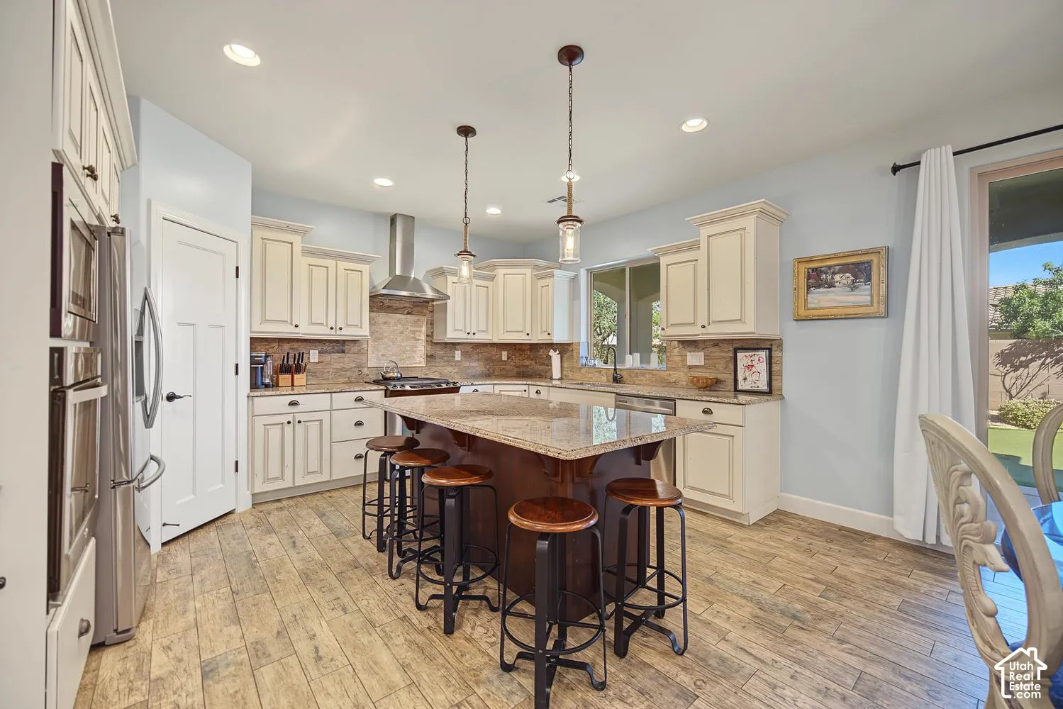 Kitchen featuring a central island with stone-finish countertops, wood-finish flooring, shaker-style cabinetry, a stainless steel chimney-style range hood, and tile backsplash
