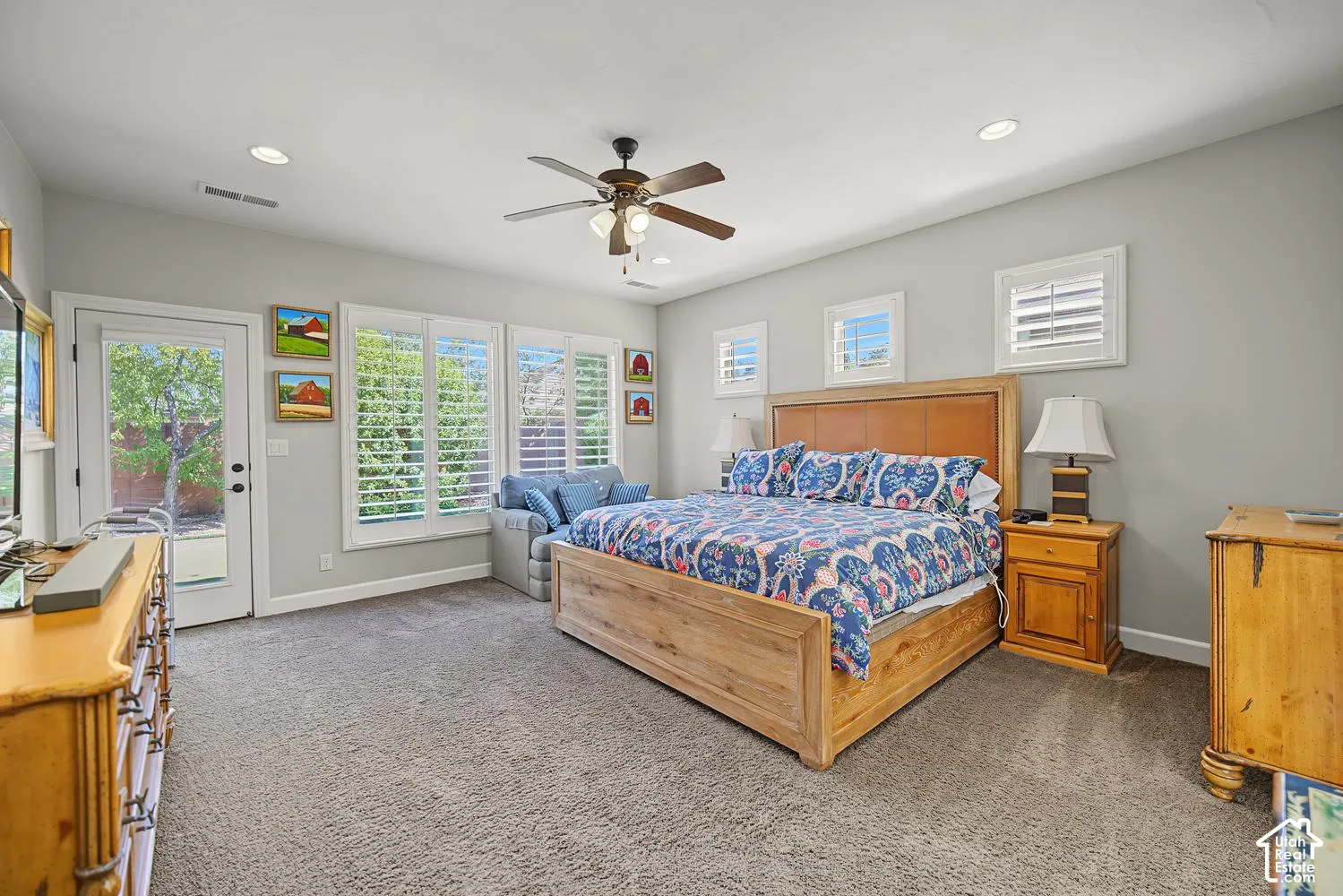 Bedroom featuring neutral wall paint, recessed lighting, ceiling fan with integrated light kit, white plantation shutters, and exterior glass-panel door