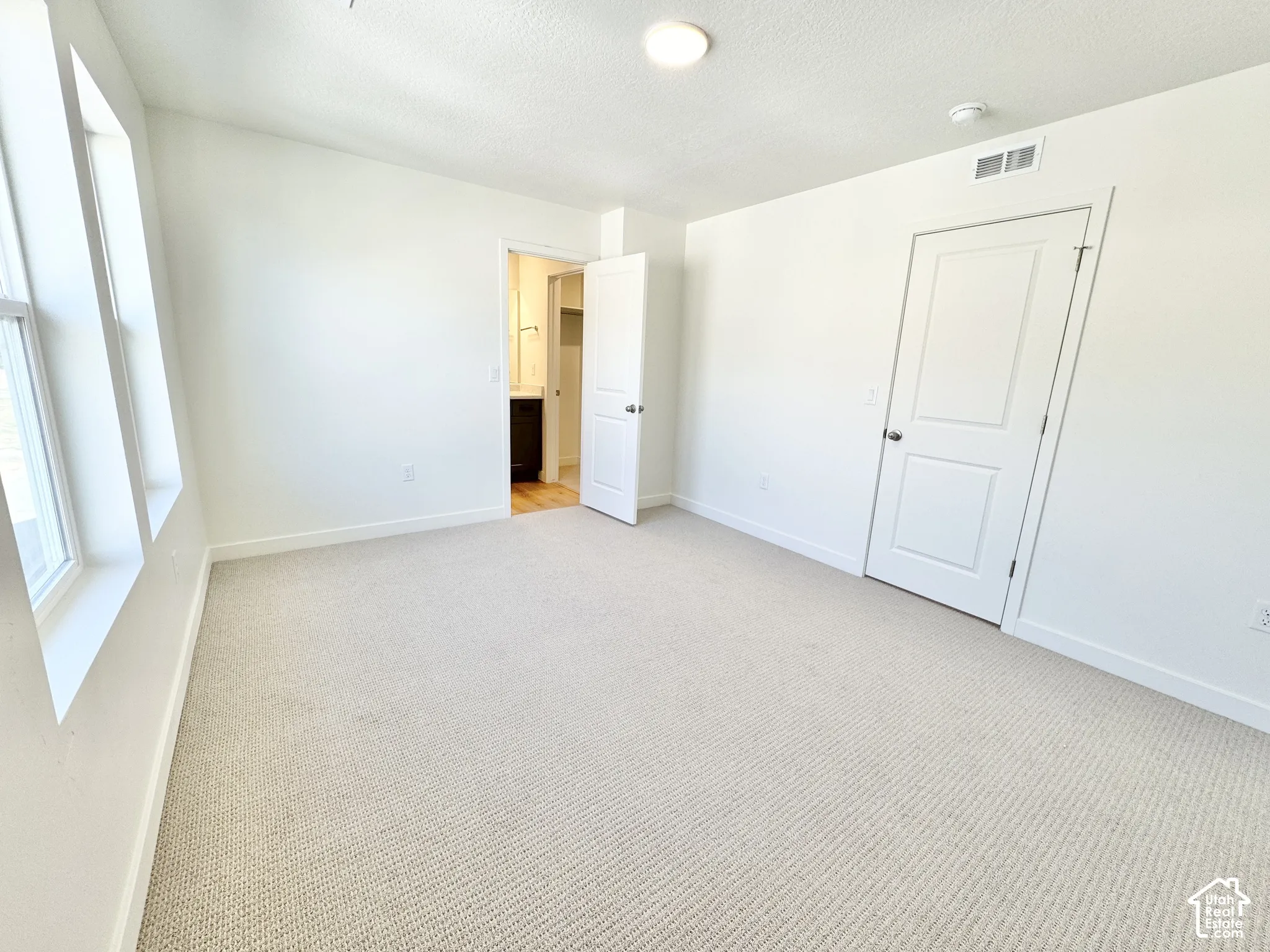 Neutral-toned wall-to-wall carpeting, crisp white walls, multi-pane windows, and interior paneled doors