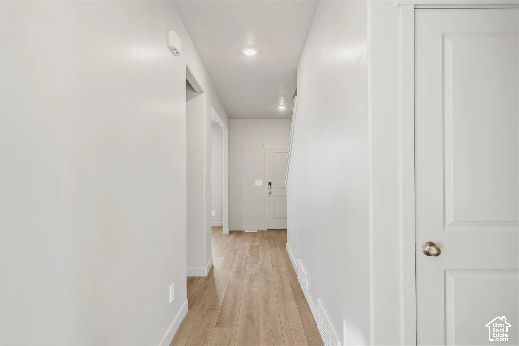 Interior hallway featuring wood-finish flooring, recessed lighting, and neutral wall paint