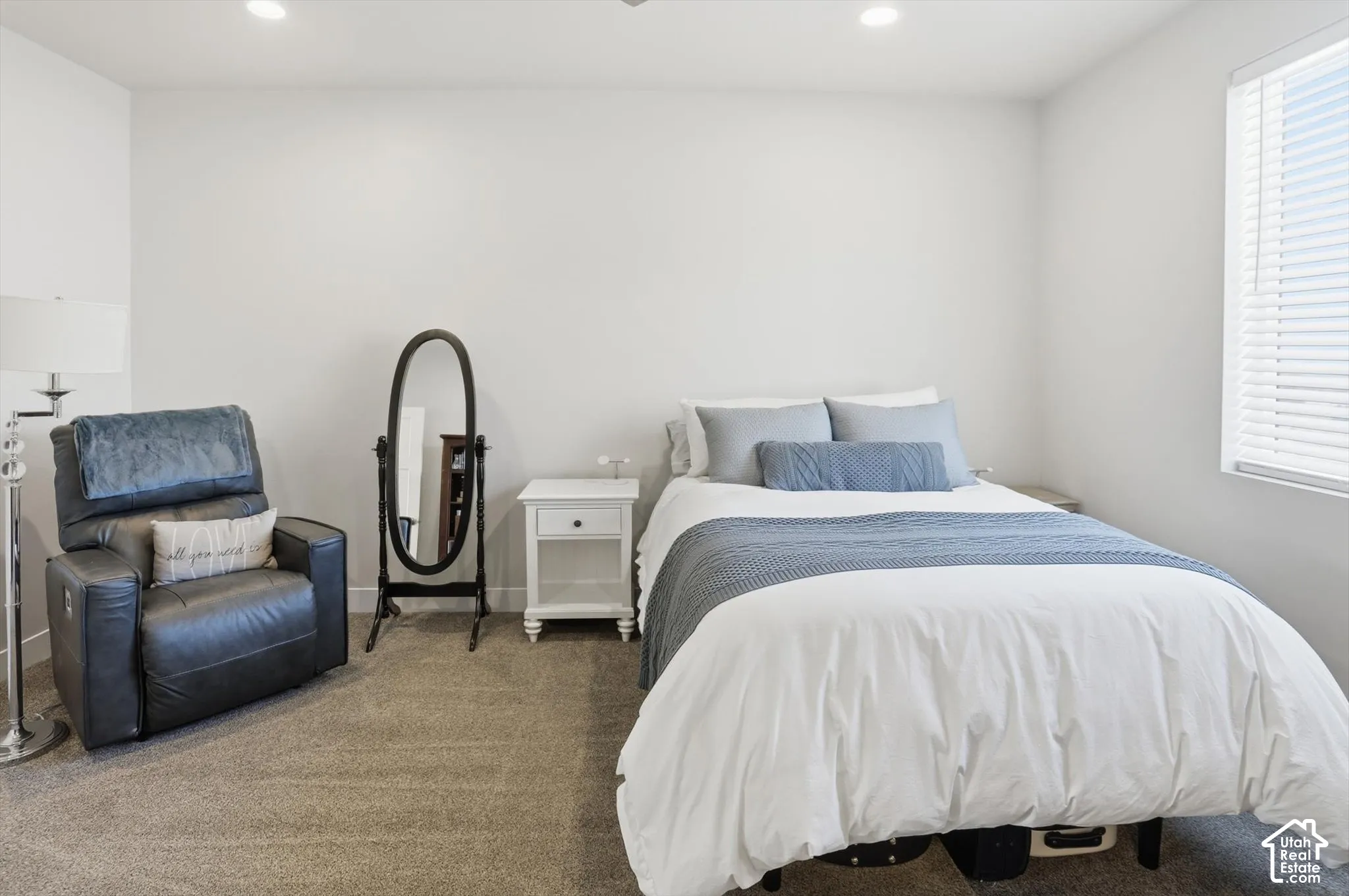 Neutral-toned wall paint, recessed ceiling lighting, wall-to-wall carpeting, and horizontal window blinds