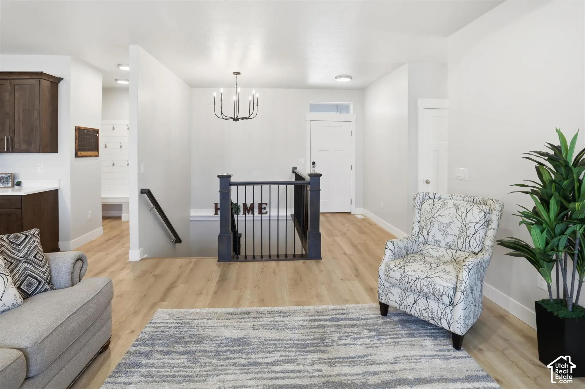 Entryway featuring wood-finish flooring, and a custom stair railing with dark-toned posts and spindles