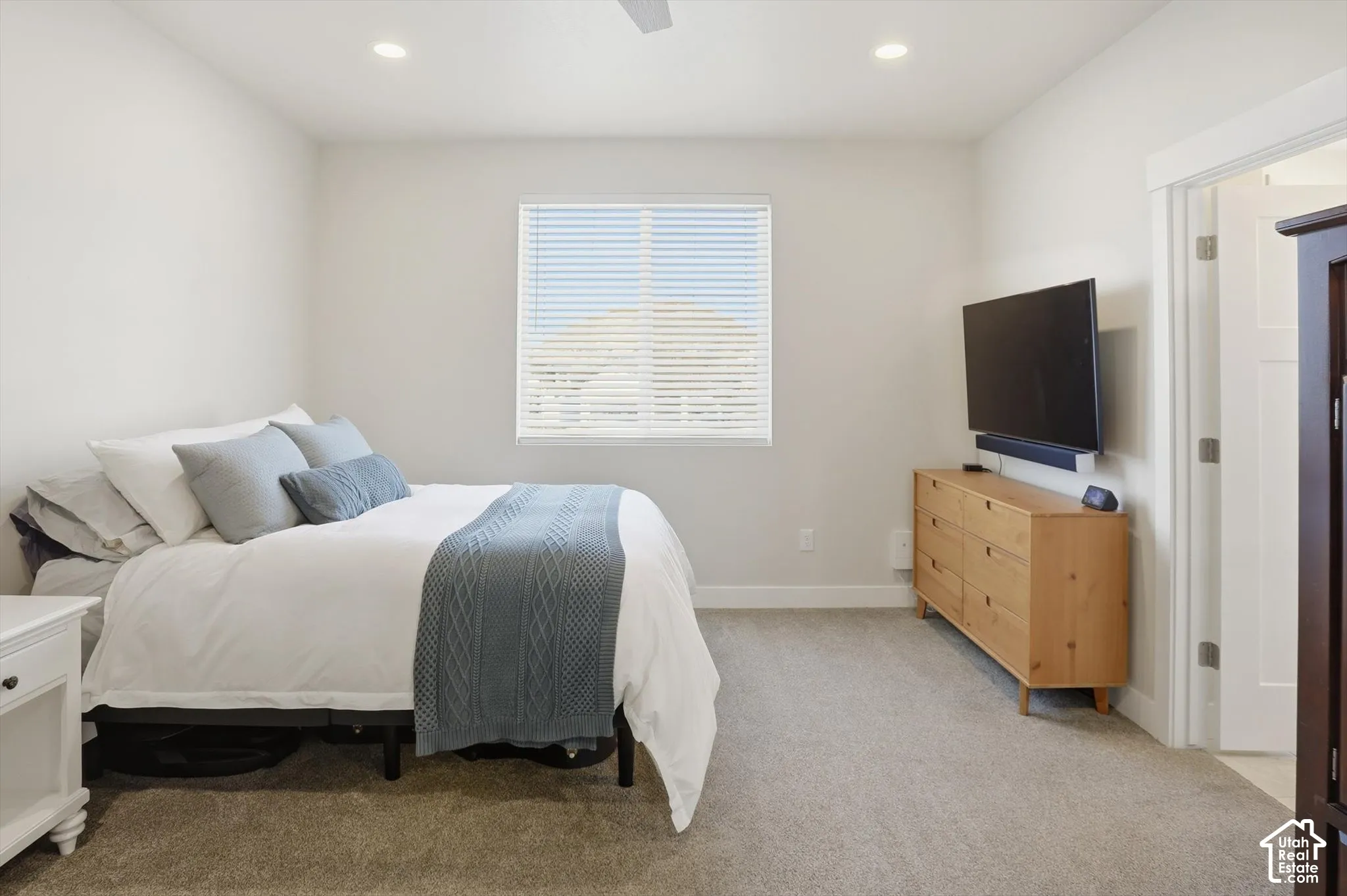 Neutral interior featuring wall-to-wall carpeting, recessed ceiling lighting, and a single-hung window with horizontal blinds