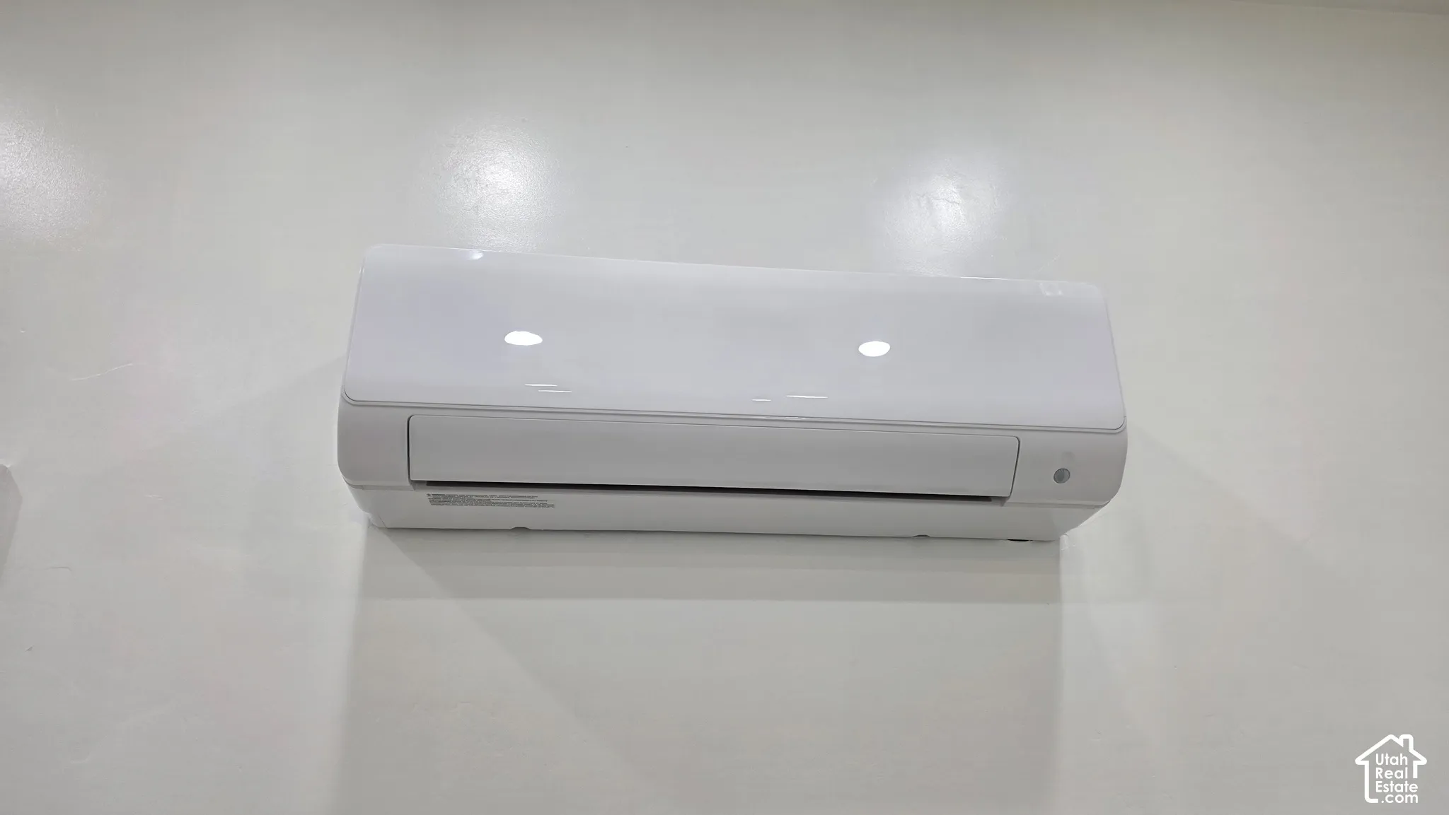 Wall-mounted ductless climate control unit featuring a white high-gloss finish