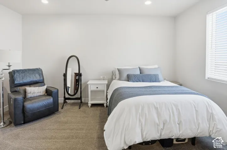 Neutral-toned wall paint, recessed ceiling lighting, wall-to-wall carpeting, and horizontal window blinds