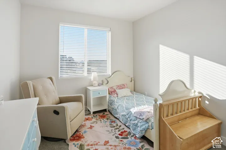 Room featuring neutral-toned walls, carpeting, and a window equipped with horizontal blinds