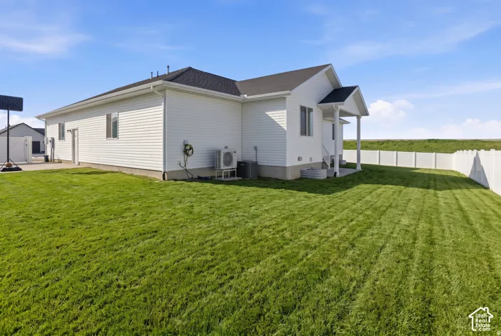 Exterior featuring white vinyl siding, a gabled roofline, a covered porch with support columns, and an enclosed backyard with a perimeter vinyl fence
