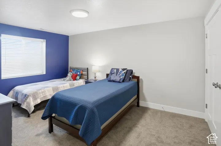 Neutral-toned interior space featuring gray carpeting, recessed lighting, and a window with horizontal blinds
