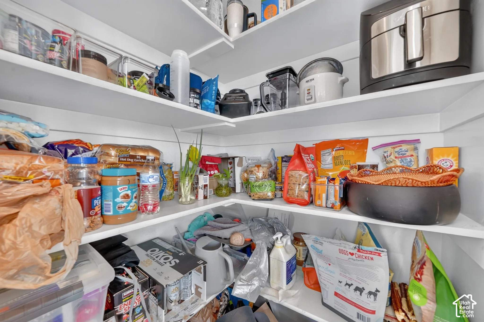 Walk-in pantry featuring white wrap-around shelving and shiplap wall detailing