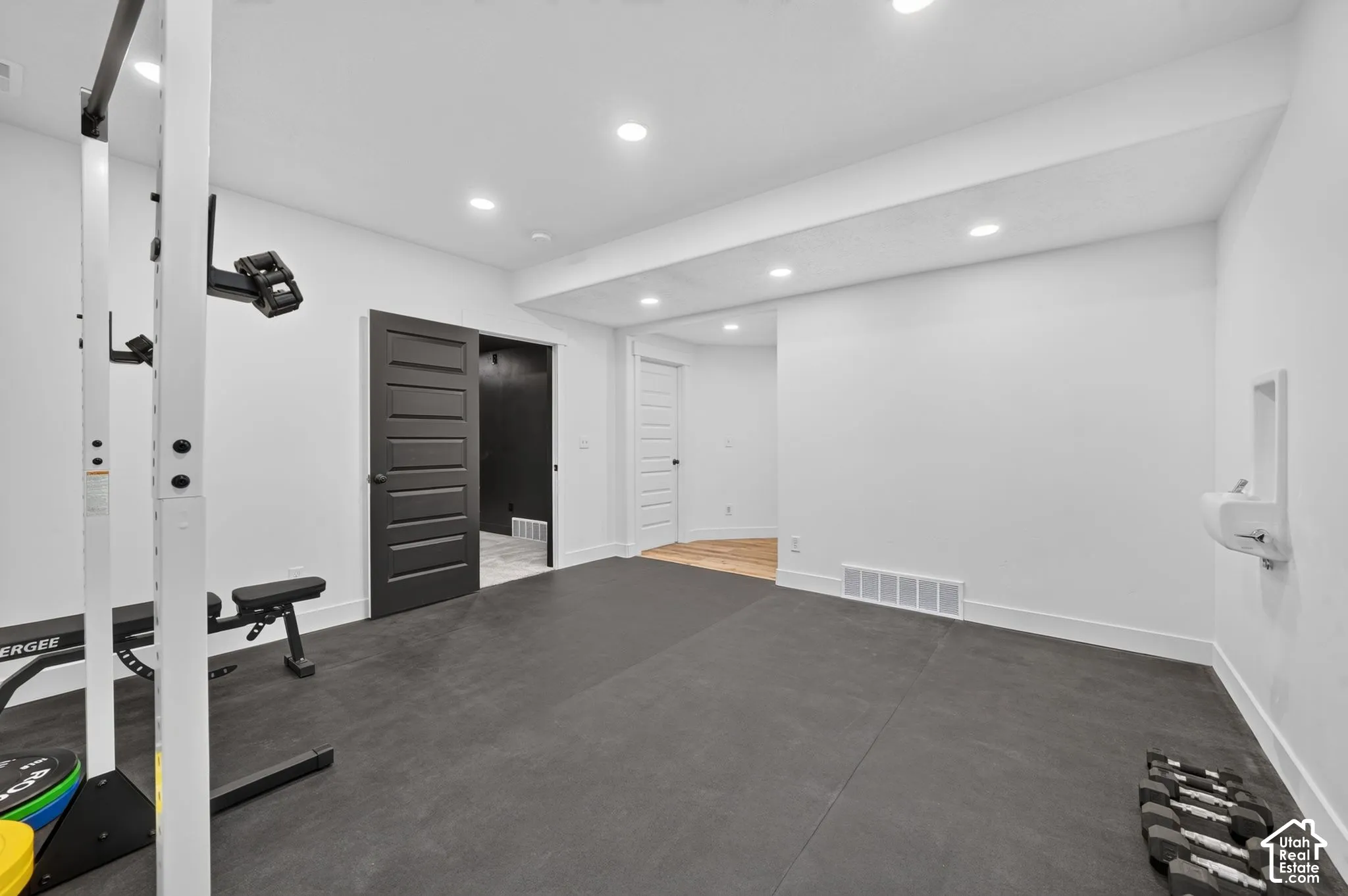 Interior space featuring recessed lighting, dark solid-core door, high-durability flooring, and built-in wall-mounted water fountain