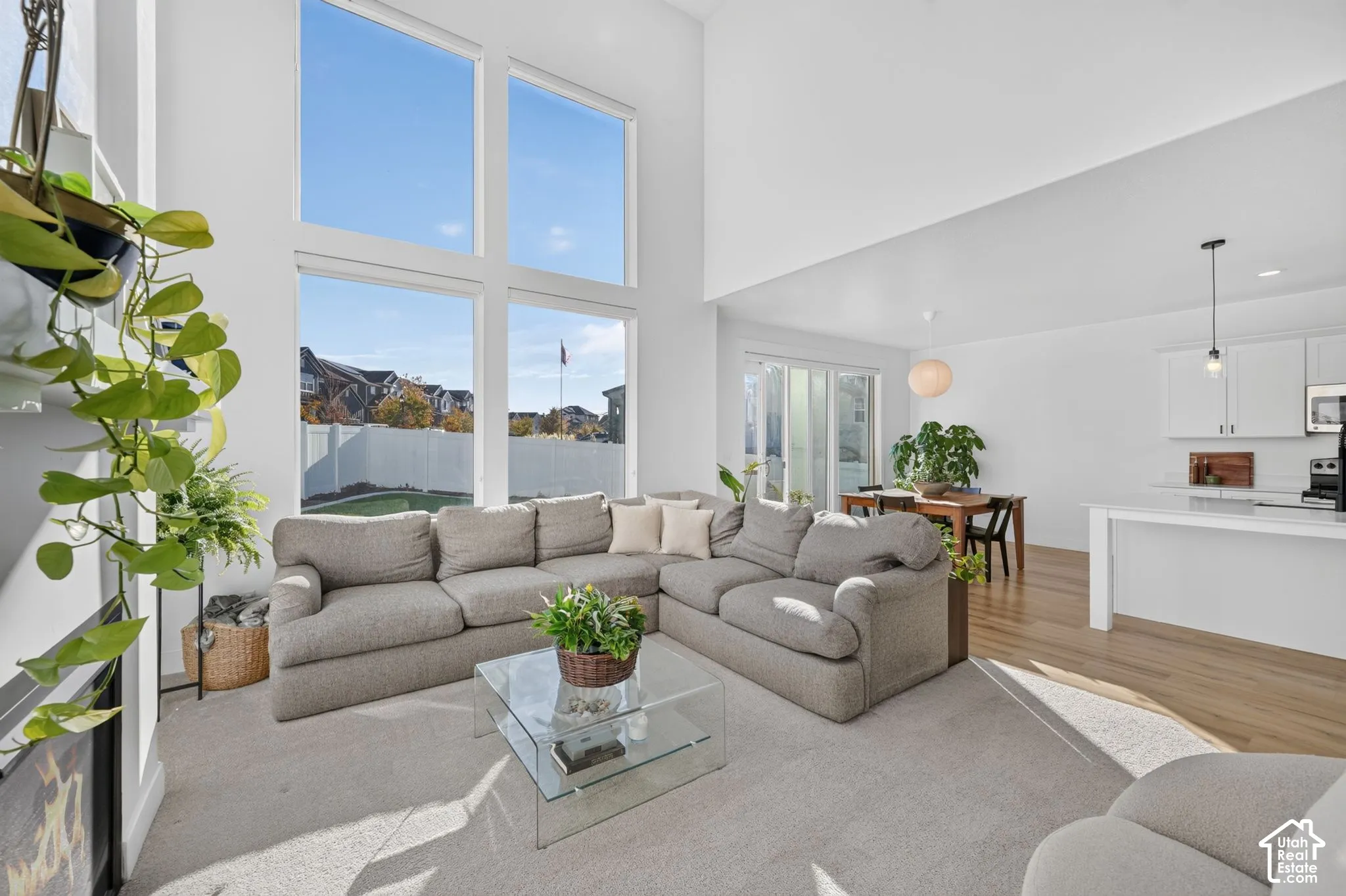 Open-concept interior featuring vaulted ceilings, floor-to-ceiling windows, wood-finish flooring, and recessed lighting