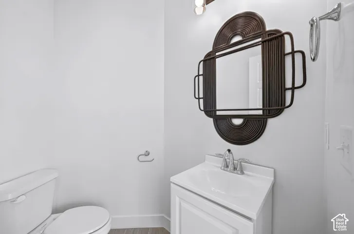 White vanity cabinet with an integrated sink and polished chrome faucet, paired with a decorative dark-finish wall-mounted mirror, overhead vanity lighting, and chrome hardware