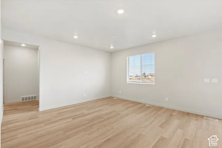 Interior space featuring wood-finish flooring, neutral wall paint, and recessed lighting