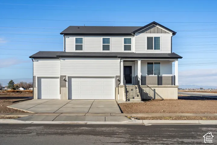 Two-story exterior featuring white horizontal siding, vertical gable accents, a concrete foundation, a covered front porch with metal railings, and a three-car garage