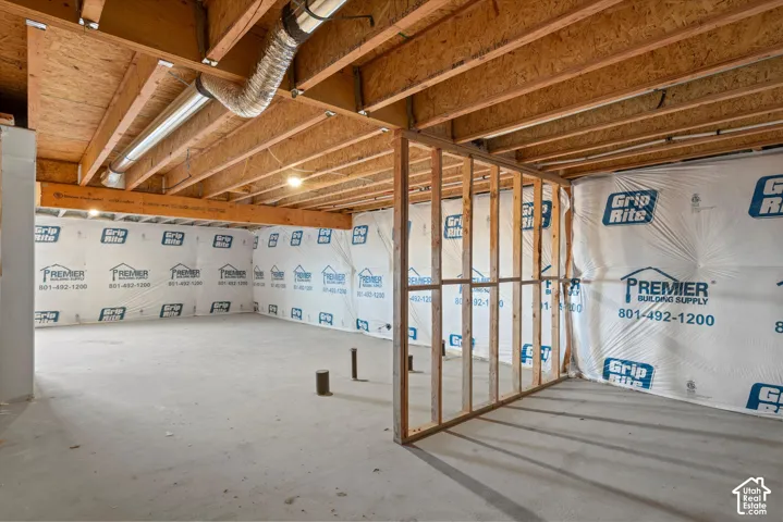 Unfinished lower level featuring exposed wood joist ceilings, concrete flooring, and structural wall framing