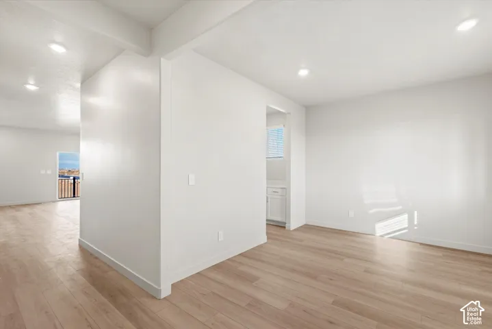 Open interior featuring wood-finish flooring, recessed lighting, and crisp white walls