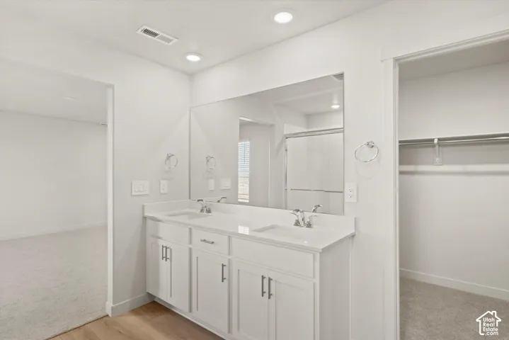 White cabinetry with dual rectangular sinks, a solid surface countertop, an expansive wall-mounted mirror, and recessed lighting