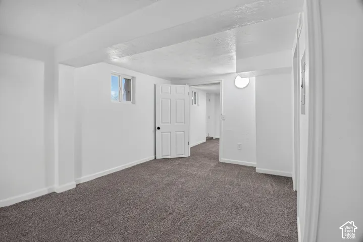 Interior space featuring neutral-toned carpeting, white-painted walls, solid-core doors, and recessed lighting