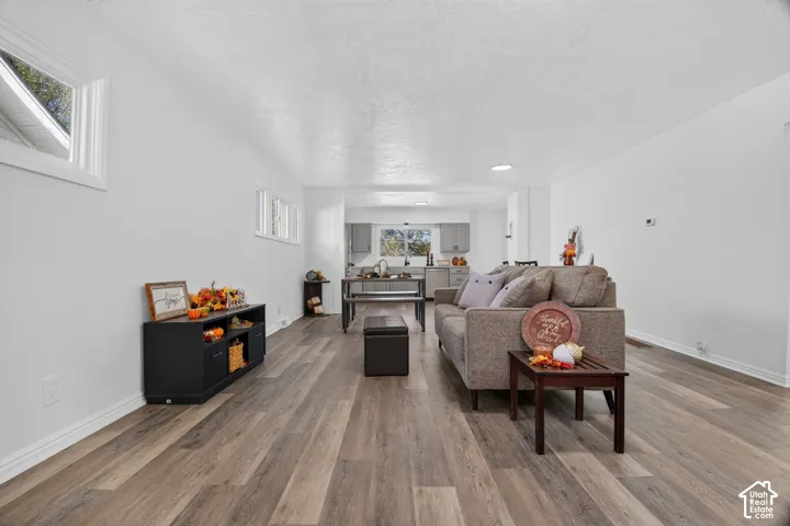 Open-concept interior featuring wood-finish flooring, recessed lighting, and crisp white wall finishes