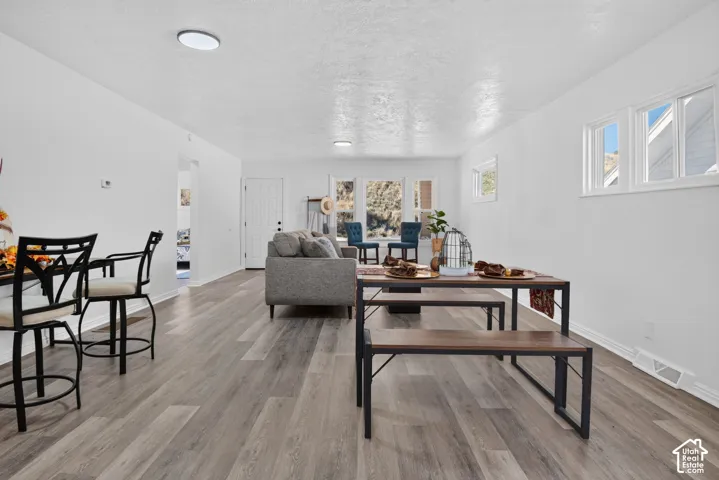 Open-concept room featuring wood-finish flooring, recessed lighting, and multiple windows with exterior mountain scenery