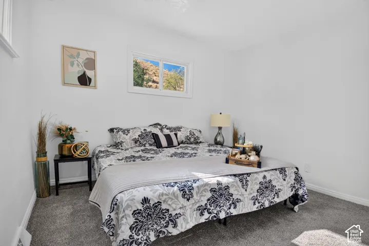 Neutral wall tones, grey carpeting, and a horizontal sliding window featuring natural hillside scenery