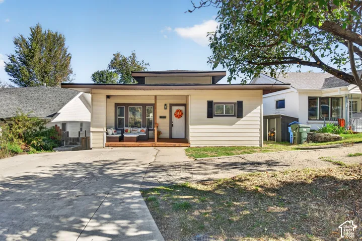 Single-story residence featuring horizontal siding, a covered front porch, low-pitch roofline, and concrete driveway