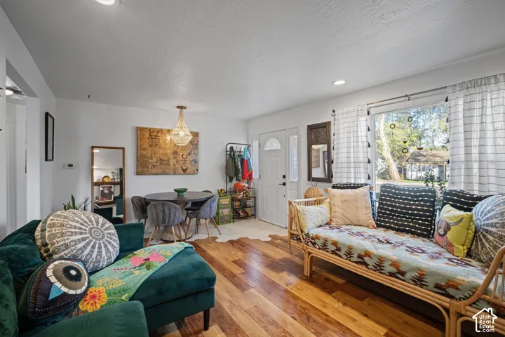 Interior featuring wood-finish flooring, recessed ceiling lighting, a hanging pendant light, a multi-pane glass entry door, and a multi-pane window