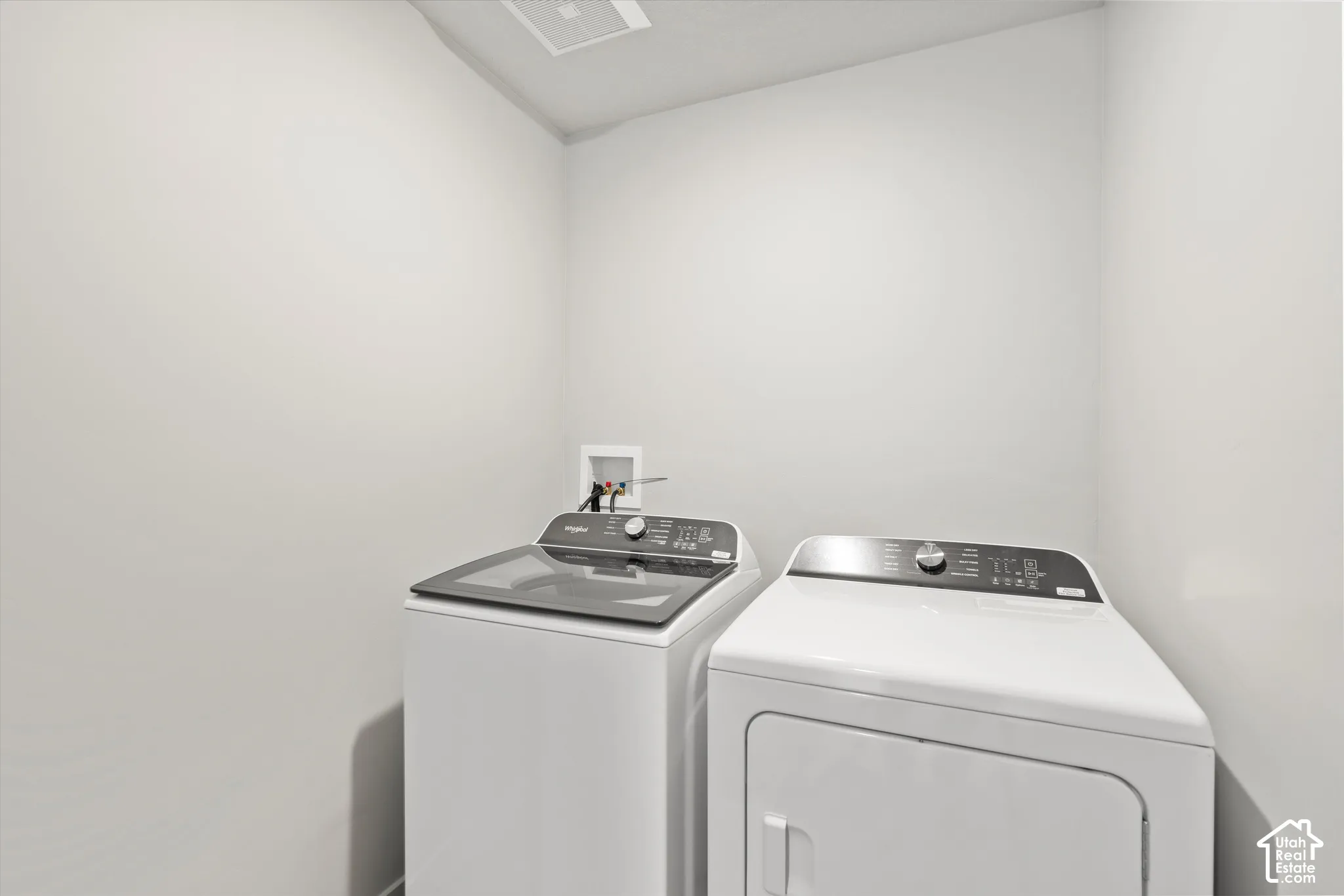 Dedicated laundry space featuring neutral wall paint and recessed utility connections