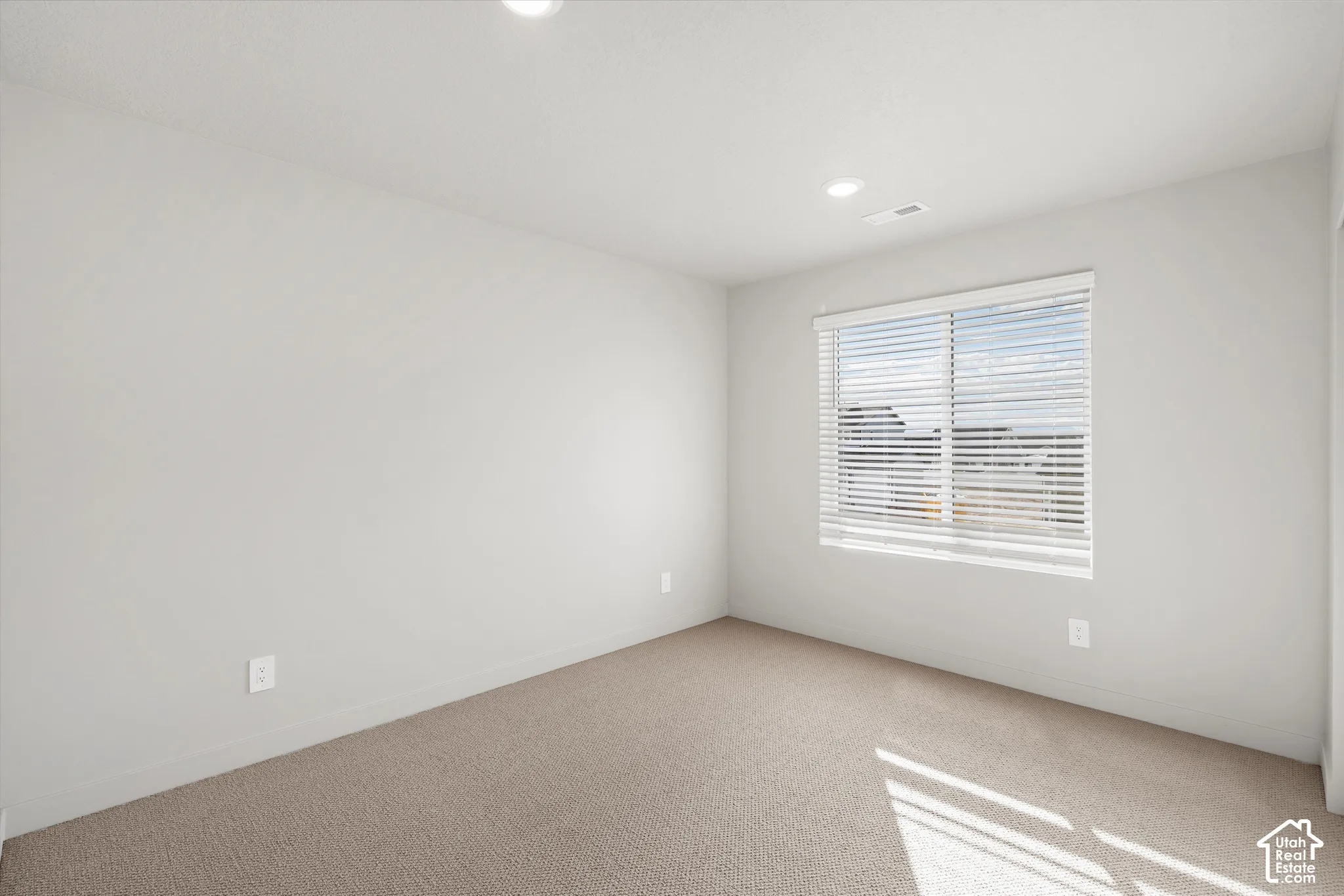 *DISCLAIMER* Interior color package may vary. Neutral-toned carpeted room featuring recessed lighting, a single window with horizontal blinds, and smooth-finish walls