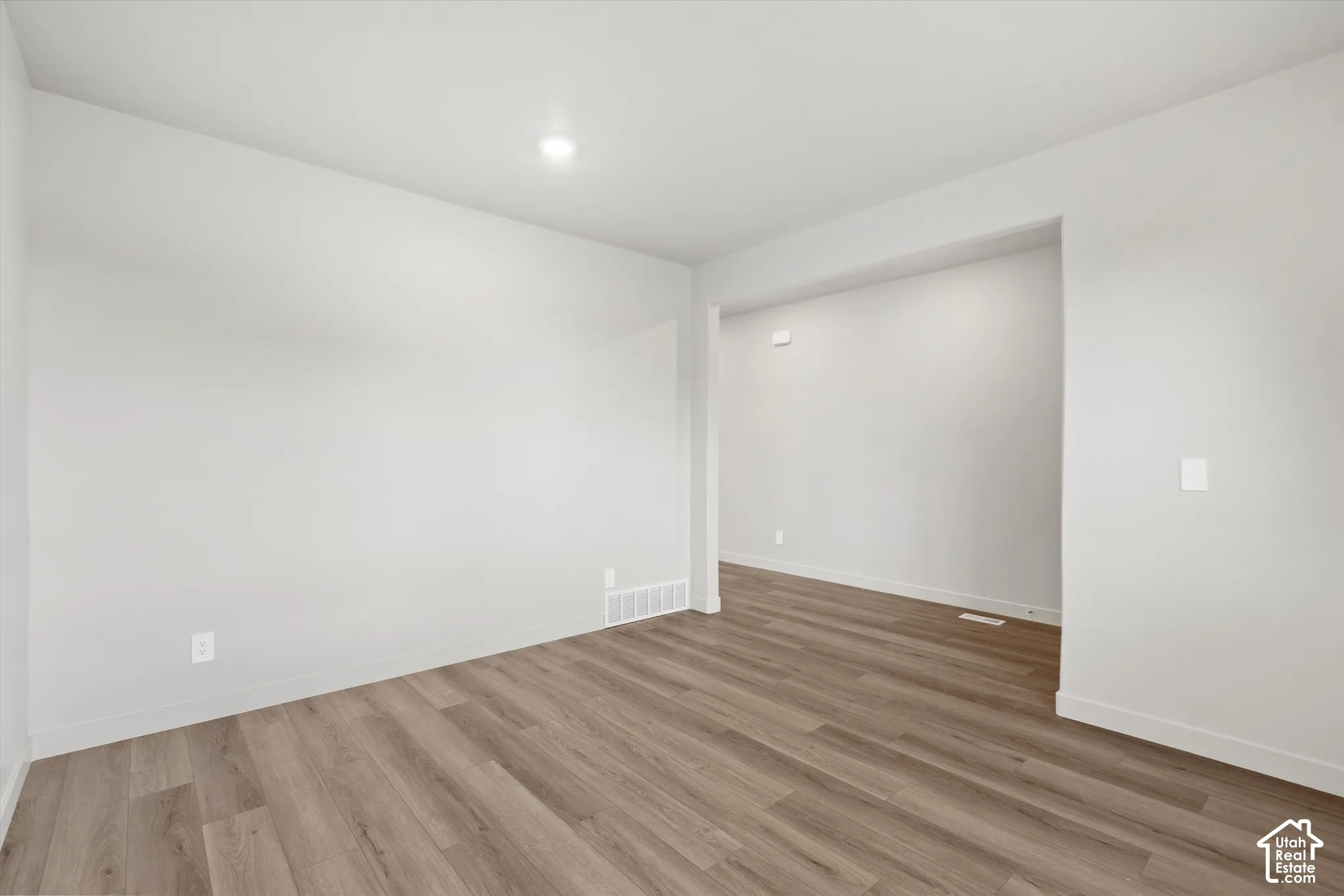 *DISCLAIMER* Interior color package may vary. Neutral-toned interior space featuring wood-finish flooring, crisp white walls, and a recessed ceiling light