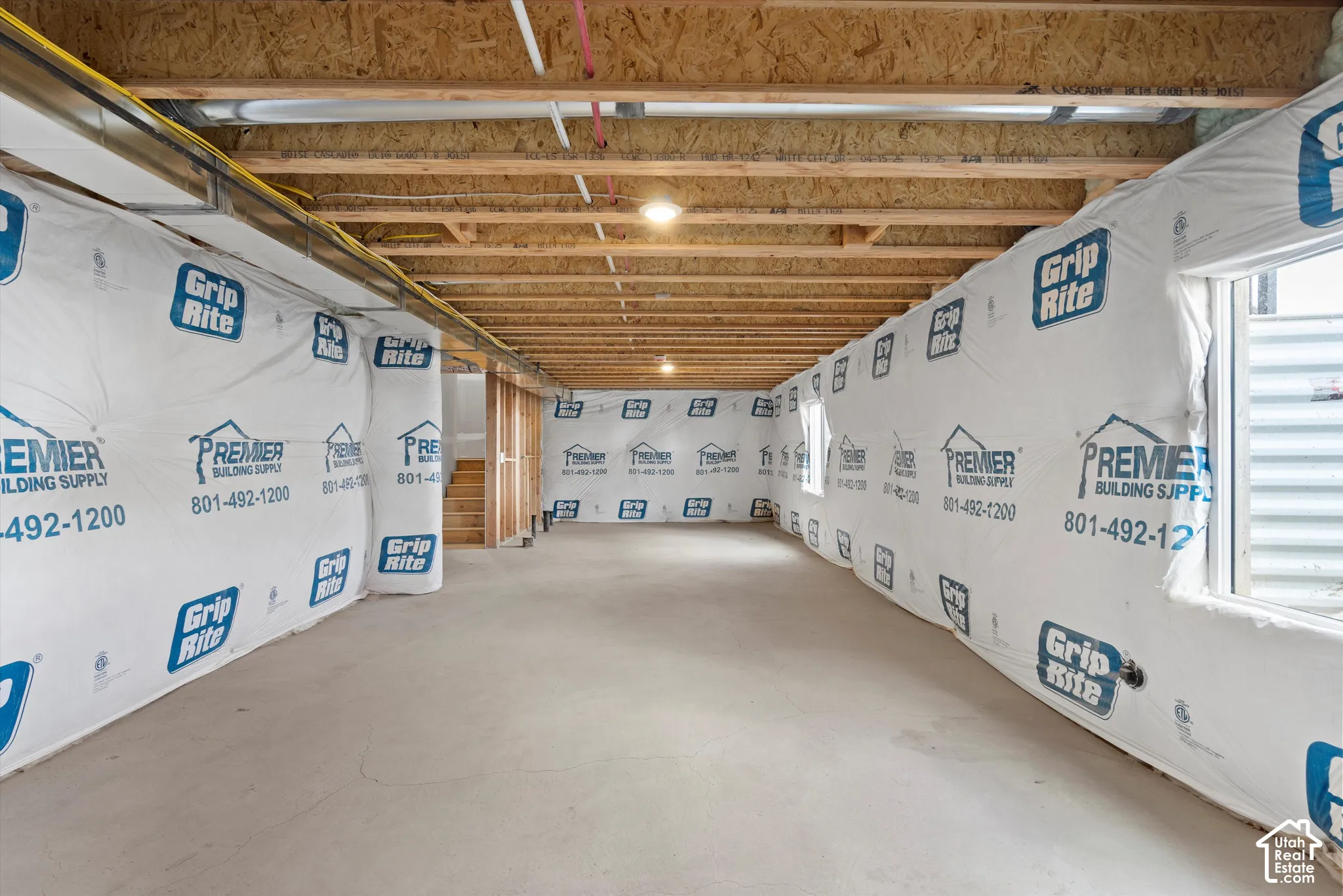 Unfinished interior space featuring exposed wood joist ceilings, concrete flooring, and window egress