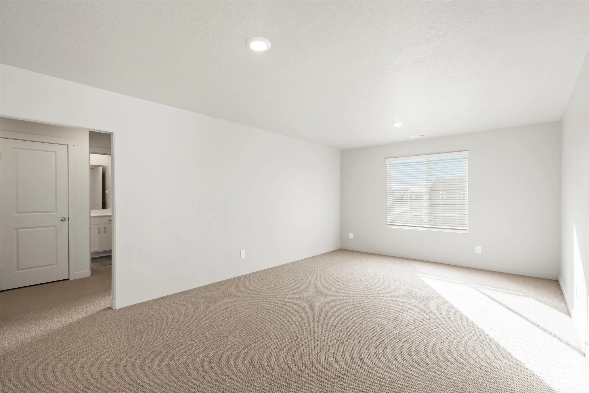*DISCLAIMER* Interior color package may vary. Interior space featuring neutral-toned carpeting, recessed lighting, a single-panel interior door, and a multi-pane window