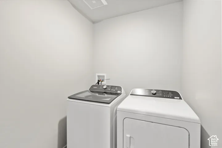 Dedicated laundry space featuring neutral wall paint and recessed utility connections