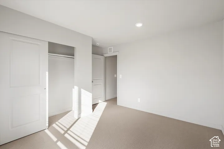 *DISCLAIMER* Interior color package may vary. Neutral-toned interior featuring wall-to-wall carpeting, recessed ceiling lighting, a sliding closet door with two-panel detailing, and white interior doors