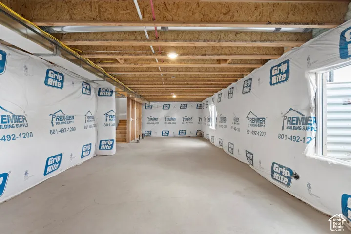 Unfinished interior space featuring exposed wood joist ceilings, concrete flooring, and window egress