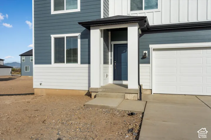 **DISCLAIMER** Elevation and exterior colors may vary. Multi-material exterior featuring horizontal lap siding, vertical board-and-batten siding, a covered entryway with square columns, and a concrete driveway