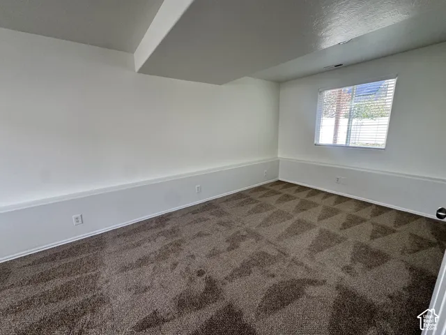 Neutral interior featuring wall-to-wall carpeting and a single-pane window with horizontal blinds