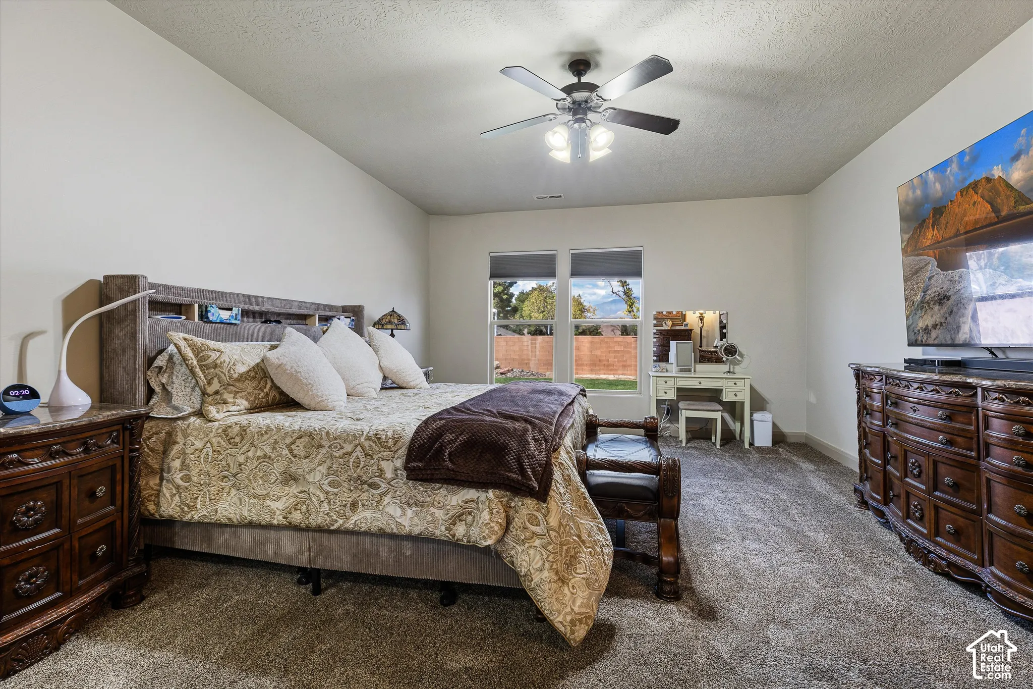 Spacious room featuring carpeting, dual-pane windows, and a ceiling fan with integrated lighting