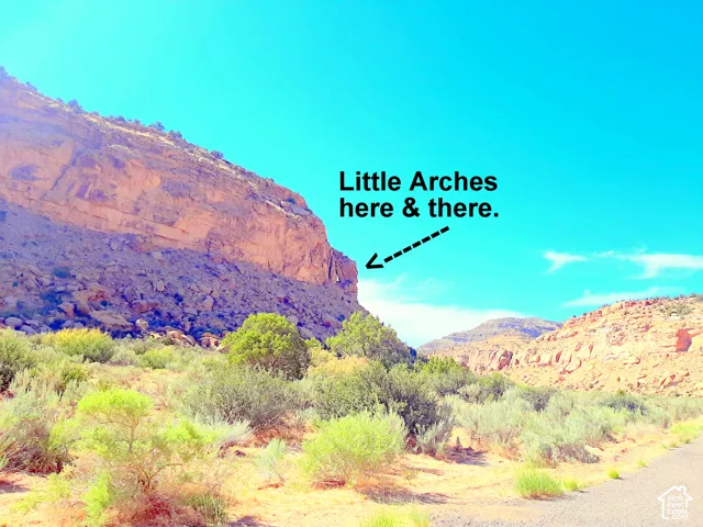 Expansive desert landscape featuring natural rock formations, geological arches, and native vegetation